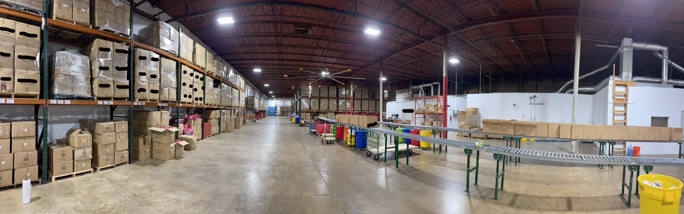 Inside a CarCovers.com fulfillment warehouse — pallet racking, inventory, and conveyor lines